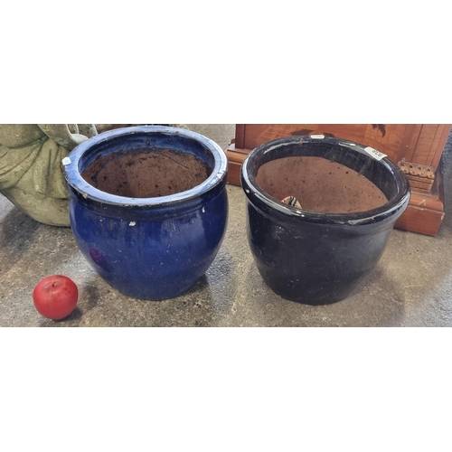 938 - Two terracotta planters in two different sizes and a black glaze finish.