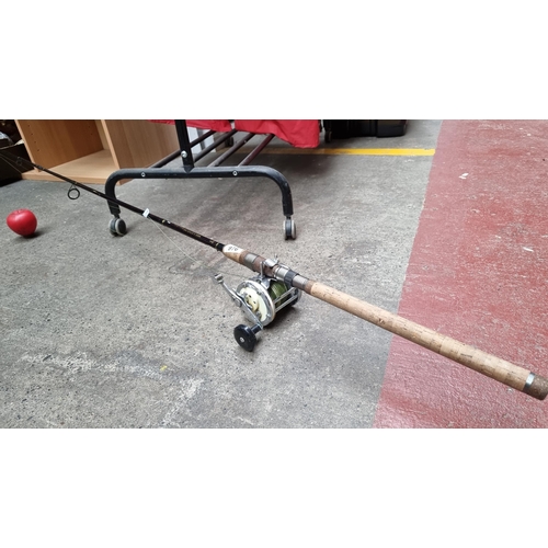 976 - A Dragon Millennium heavy duty sea fishing rod complete with reel and bamboo handle.