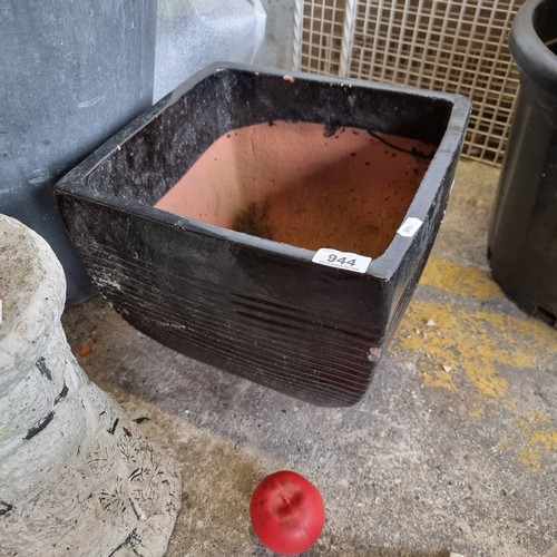 944 - A large terracotta square planter in a black glaze.