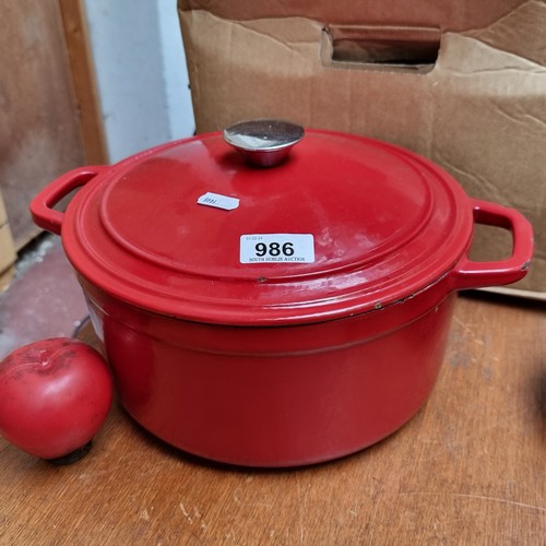 A cast iron heavy dutch oven with lid in a red finish. In lovely condition.