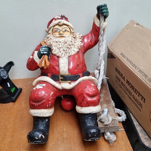 988 - A cheerful large Santa Clause figure who sits on the wooden swing.