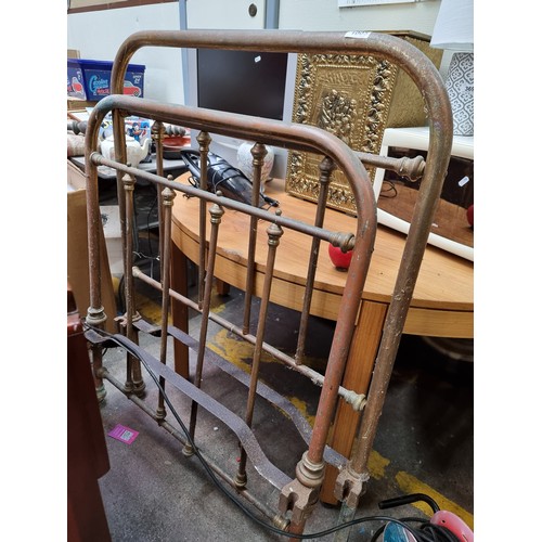 1005 - An antique cast metal bed frame with slatted foot and headboard and decorative finials. Headboard an... 