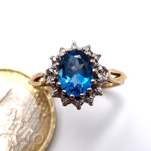 676 - Star Lot : A beautiful blue topaz ring with diamond cluster surround, mounted in 9K gold (375), ring... 