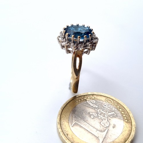 676 - Star Lot : A beautiful blue topaz ring with diamond cluster surround, mounted in 9K gold (375), ring... 