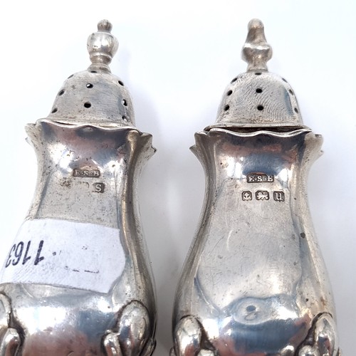 696 - Two sterling silver pepperettes standing on four paw feet, hallmarked Birmingham, height 8cm, set wi... 