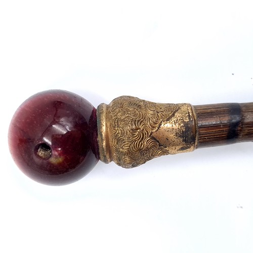 700 - The top of a cane finished with silver ferrule with a gilt mount finished with a polished gem fittin... 