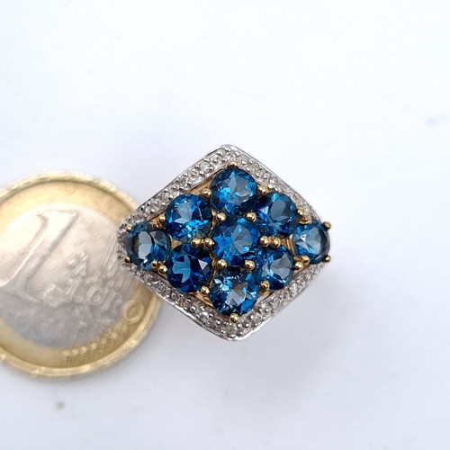 763 - Star Lot : A super quality 9K gold nine stone topaz and diamond brilliant cut ring, hallmarked Birmi... 