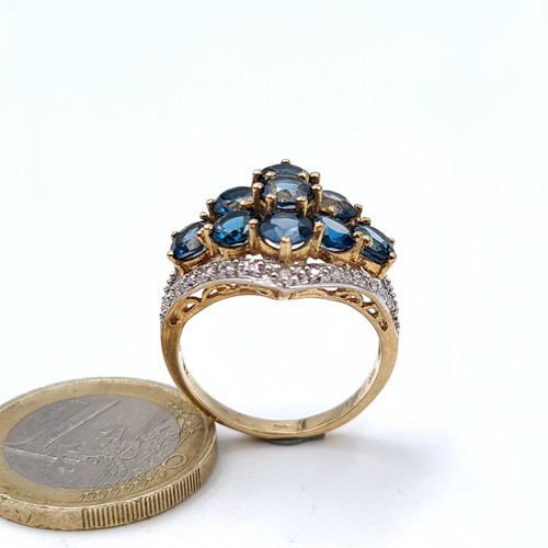 763 - Star Lot : A super quality 9K gold nine stone topaz and diamond brilliant cut ring, hallmarked Birmi... 