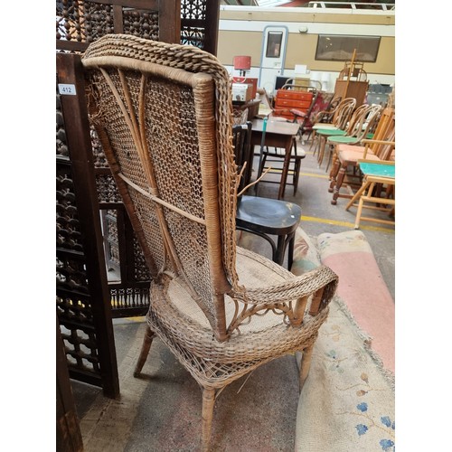 411 - A spectacular antique wicker occasional chair with an ornate detailing to backrest in the form of th... 