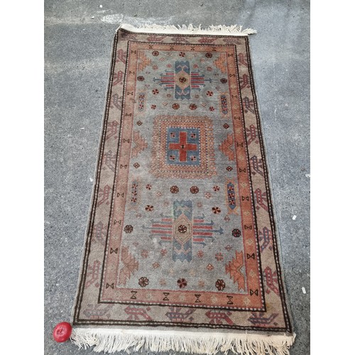 409 - A cheerful handwoven wool rug boasting a geometric and floral design in shades of blue, red and crea... 