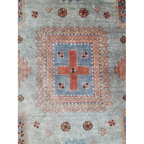 409 - A cheerful handwoven wool rug boasting a geometric and floral design in shades of blue, red and crea... 