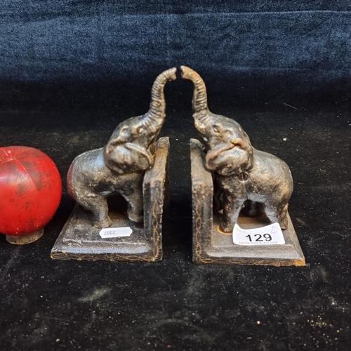 129 - A pair of cast metal elephant book ends with raised trunks.