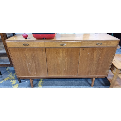 425 - Star Lot : A stunning large Mid Century teak sideboard featuring three pull out drawers and three ca... 