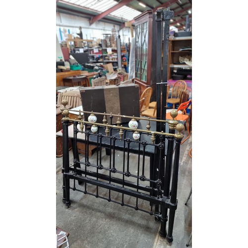 819 - Star Lot : A stunning cast iron bed frame including headboard and footboard. Featuring brass finial.... 