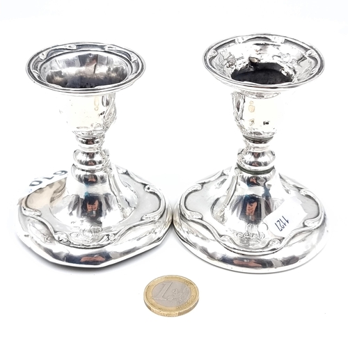 610 - A pair of sterling silver candle holders, hallmarked Birmingham 1938, height 9cm, base 7cm diameter.