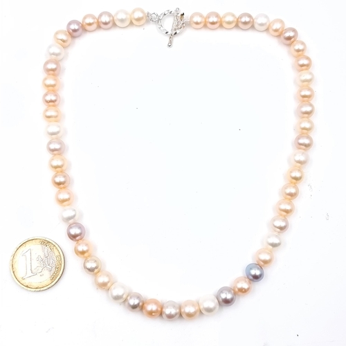 650 - A graduated natural lustre pearl necklace set with sterling silver t-bar clasp, length of necklace 4... 