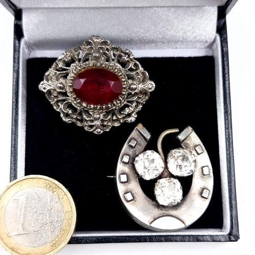 661 - Two antique brooches including a three stone horseshoe and a red tourmaline stone example, pins inta... 