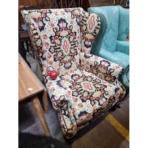 702 - Star Lot : A superb vintage wingback armchair with gorgeous brass stud detailing, upholstered in a v... 