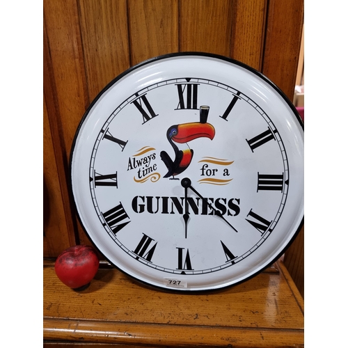 727 - A fabulous large enameled metal wall clock advertising Guinness. Battery powered.