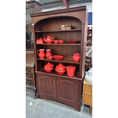 743 - A handsome bookcase holding three shelves to top, with cupboard to base holding a single shelf insid... 