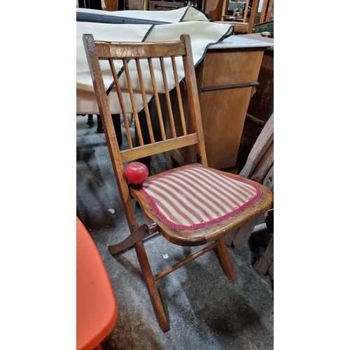 796 - A handsome Edwardian foldable spindle back chair with upholstered seat.