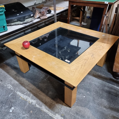 799 - A fantastic contemporary coffee table featuring a smoked glass top. Approx a meter squared.