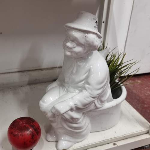 147 - A vintage ceramic plant pot depicting a lady sitting on a toilet.