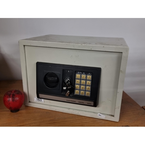 163 - An electronic digital safe with working key. Can be screwed to the floor or wall for security.