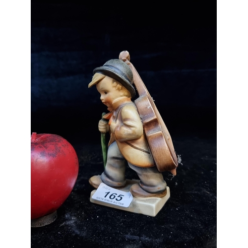 165 - A vintage German Hummel figurine depicting a child carry a double bass on his back, probably going t... 