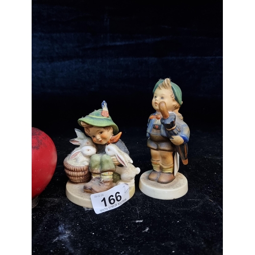 166 - Two vintage Hummel figurines depicting boy with rabbits and a a boy with an umbrella.