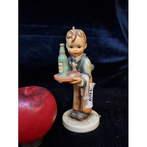 169 - A vintage German Hummel figurine depicting a little boy waiter.