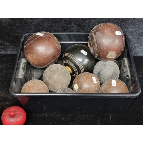 228 - A box containing nine vintage lawn bowls. Including some very old rare examples.