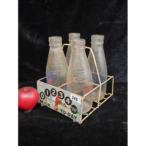 245 - A fabulous 1980's milk carrier crate containing four glass milk bottles including  Dublin 