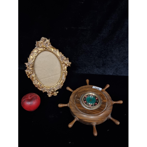 268 - Two items including a wall clock in the form of a ships wheel with a working roulette table with a s... 