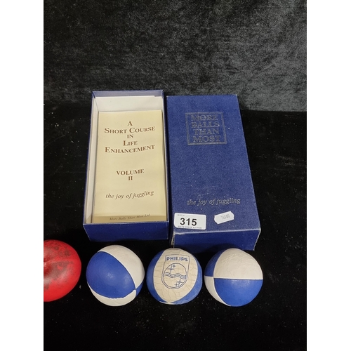 315 - A super fun set of juggling balls including a Phillips branded example, all held in a case reading 