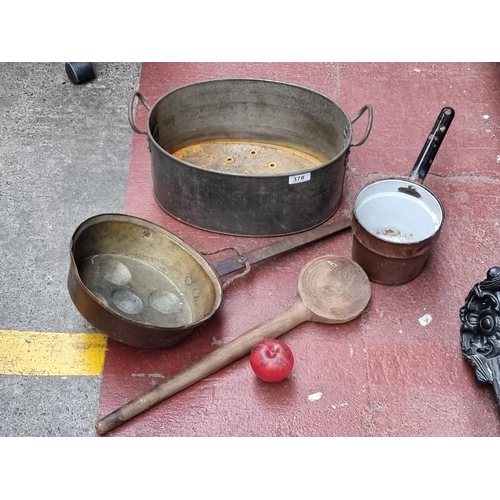 378 - Four antique kitchen cooking utensils including a large wooden spoon, saucepan, strainer and a wonde... 