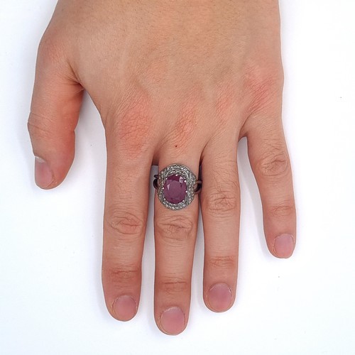 16 - Star Let : A large ruby stone ring of 12.3cts with a diamond surround of 0.5cts set in sterling silv... 