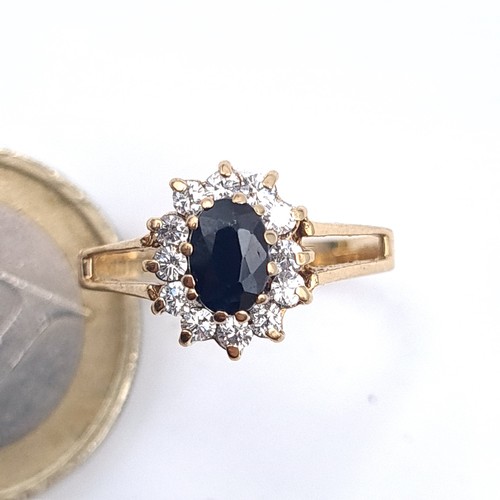 640 - Star Lot : A gem set cluster ring with a sapphire central stone set in 9K gold, size M, weight 1.8 g... 