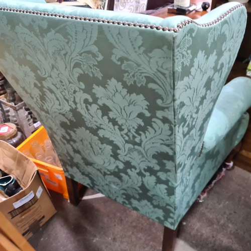 703 - Star Lot : A superb vintage wingback armchair with gorgeous brass stud detailing, upholstered in a v... 