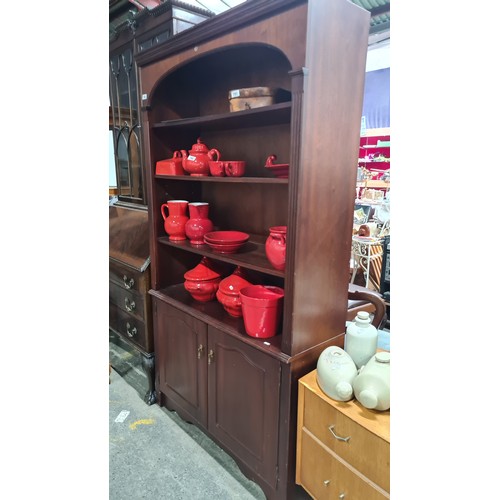 743 - A handsome bookcase holding three shelves to top, with cupboard to base holding a single shelf insid... 