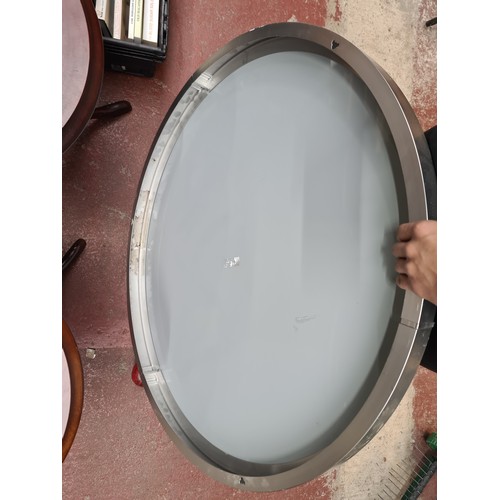 387 - A chic contemporary round beveled wall mirror held in a chrome frame.