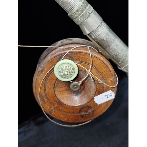 383 - A lovely vintage fishing pole with cork handle and wooden reel. In a dark green finish.