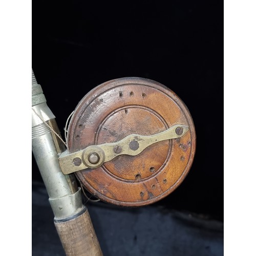 383 - A lovely vintage fishing pole with cork handle and wooden reel. In a dark green finish.