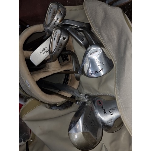 384 - A Ram golf bag holding ten Ram branded golf clubs including irons, putter and three drivers with bra... 