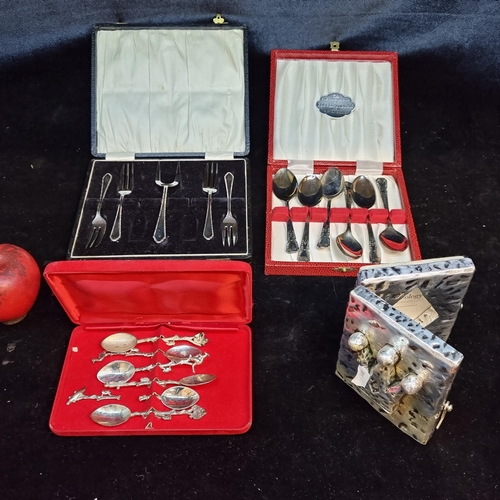 186 - A box of four items including a set of Australian themed teaspoons, a hammered metal picture frame, ... 