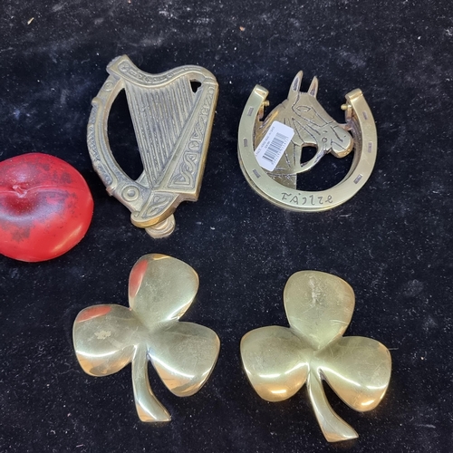 189 - A box of four brass items including two doorknockers and two shamrock plaques.