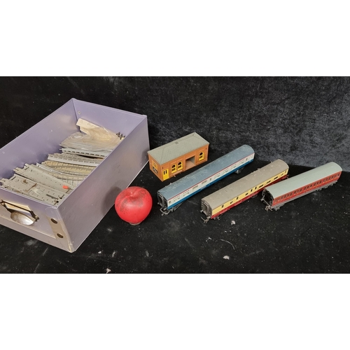 233 - A box containing a selection of vintage Hornby train accessories including carriages, tracks, and a ... 