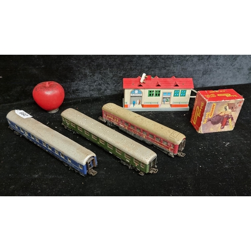 289 - A selection of five railway items including a Tri-ang railways fog signal, a colourful station and t... 