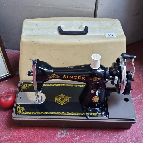 364 - A vintage Singer sewing machine with classic gilt decals. Includes carry case. Very clean handsome e... 