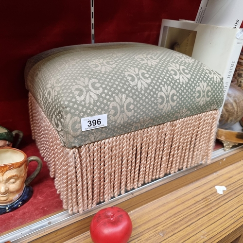 396 - An elegant padded and upholstered foot stool with fringe detailing. In lovely condition from a very ... 